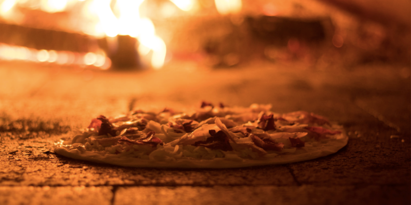 pizza cooking in wood fired oven