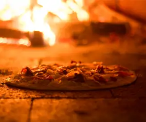 pizza cooking in wood fired oven