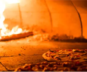 pizza cooking in wood fired oven